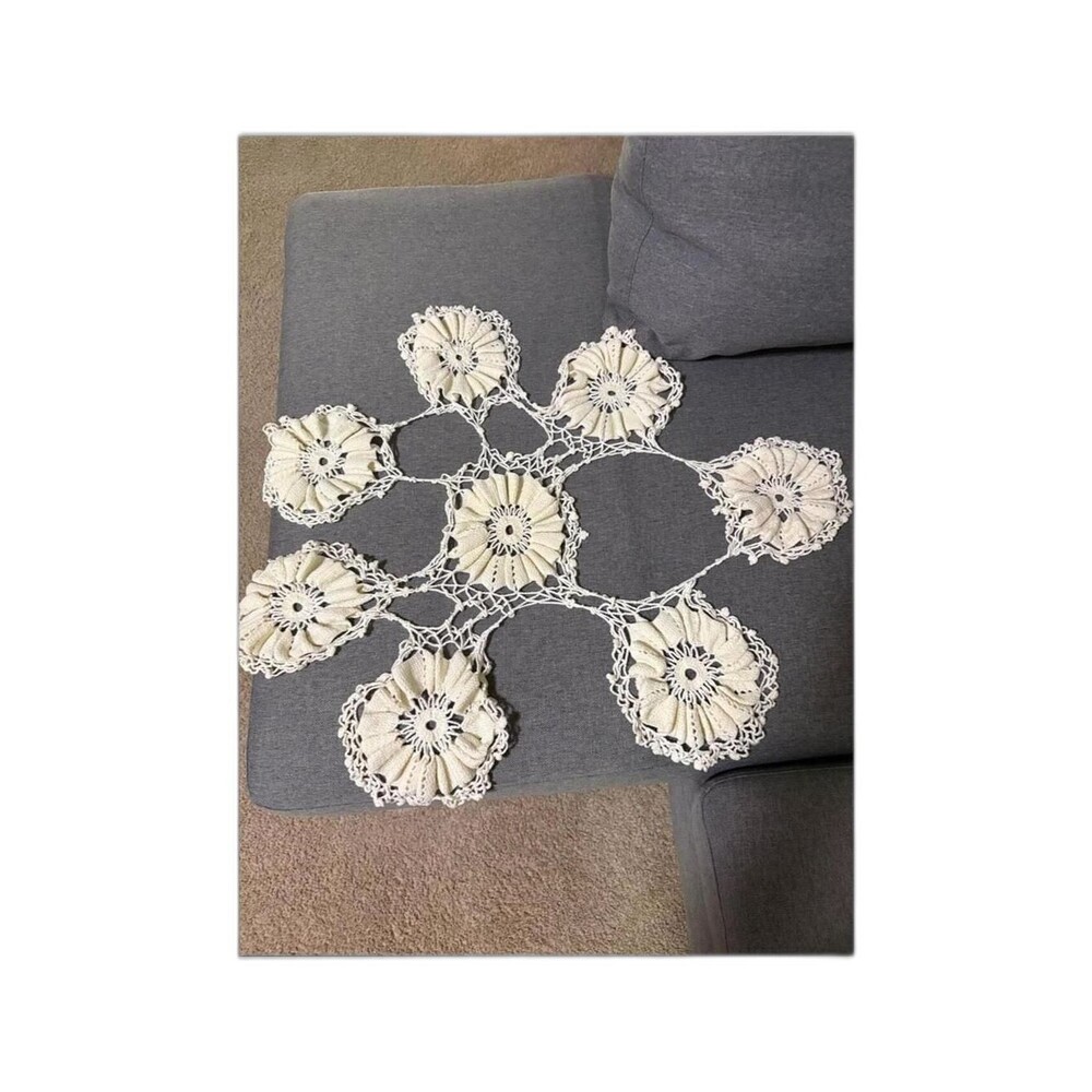 Handcrafted cream crochet with layered floral motifs.